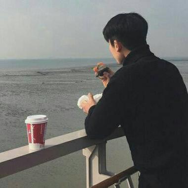 一个男生坐在海边的背影头像